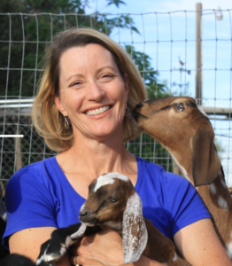 Kate Johnson posing with two goats.