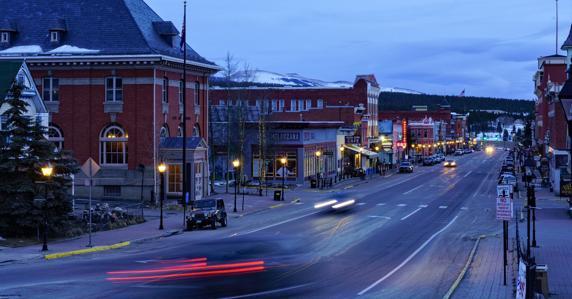 Long exposure image of cars driving through downtown Leadville Colorado at dus