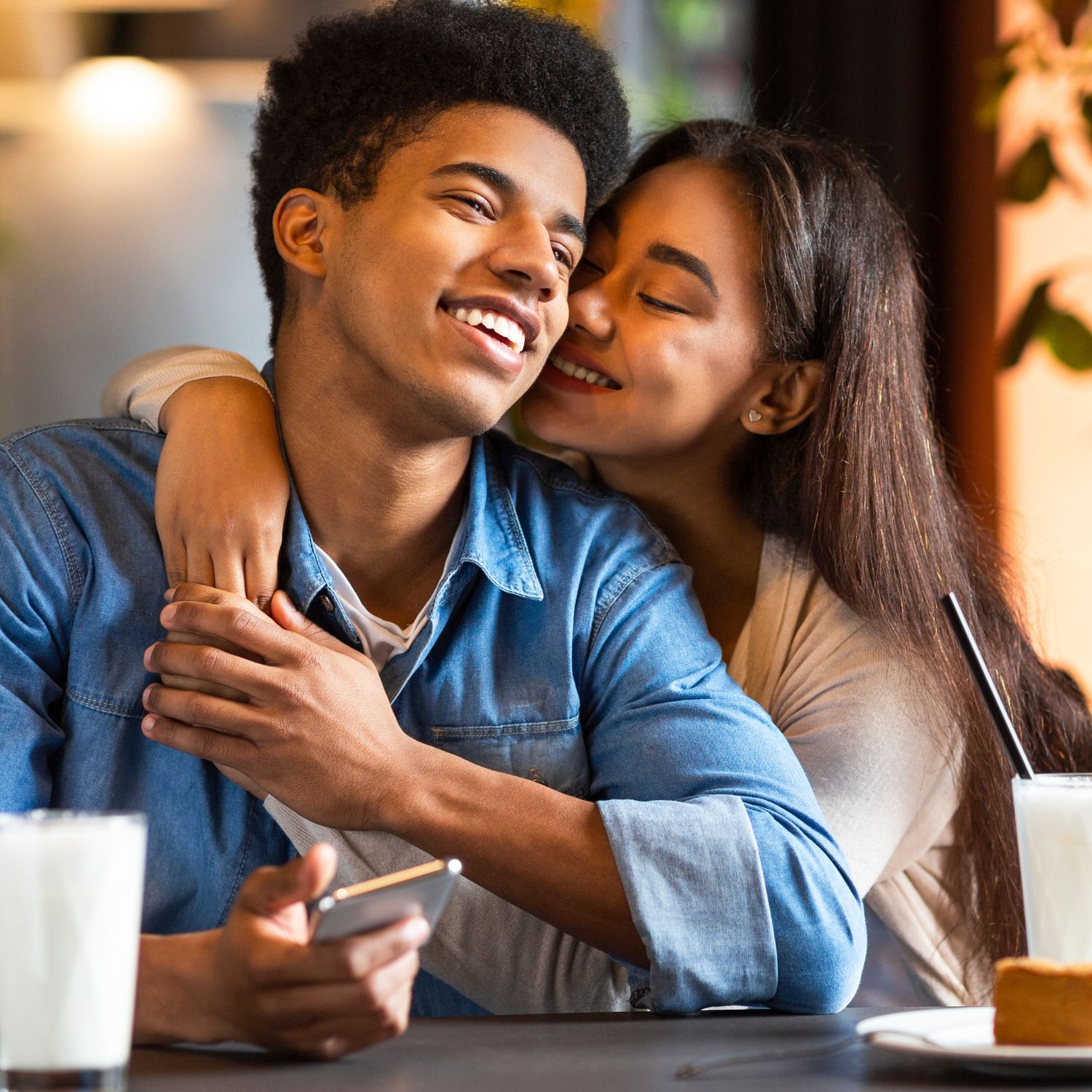 Two teens embrace at a restaurant