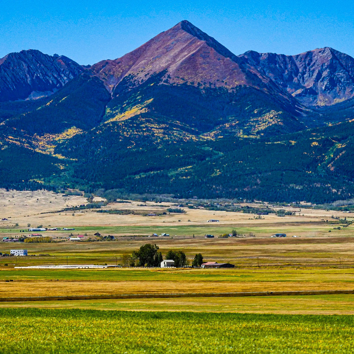 Horn Mountain towers behind acres of farmland in Westcliffe, Colorado.