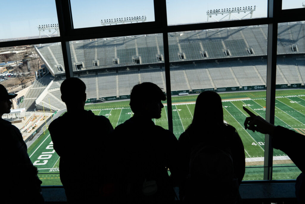 Silhouettes of students with CSU's football field in the background