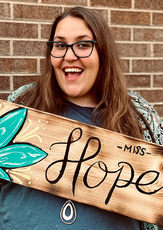 Cheyanne Hope holds a sign reading "Miss Hope"
