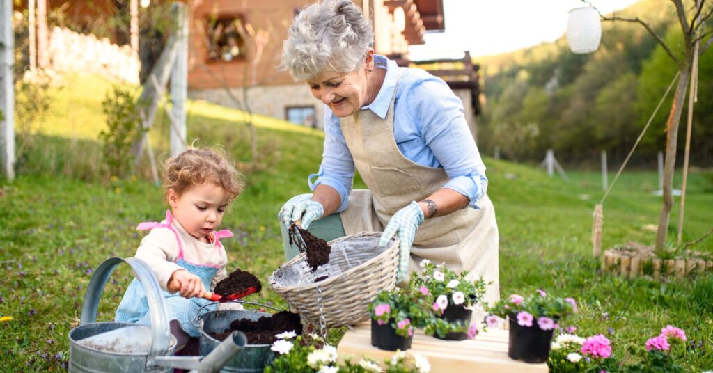 An elderly woman gardening with a young child
