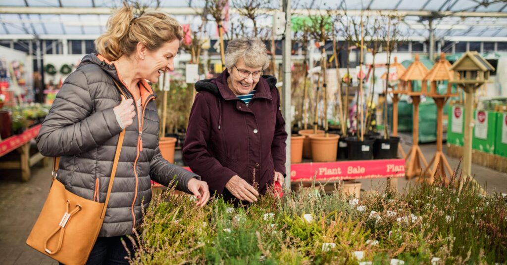 Two middle-aged women buying plants at a garden store